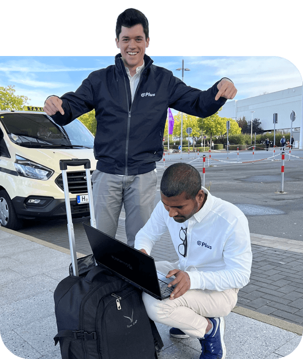 Plus employees with luggage at airport one working on laptop computer