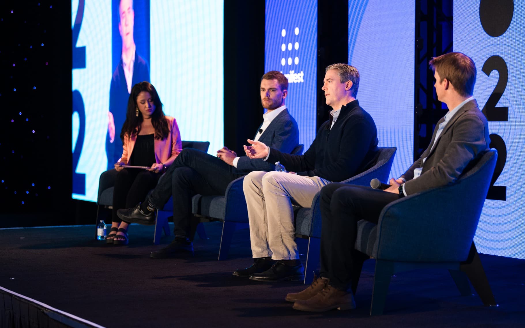 Panel discussion with 4 members on stage at Manifest 2022 Conference