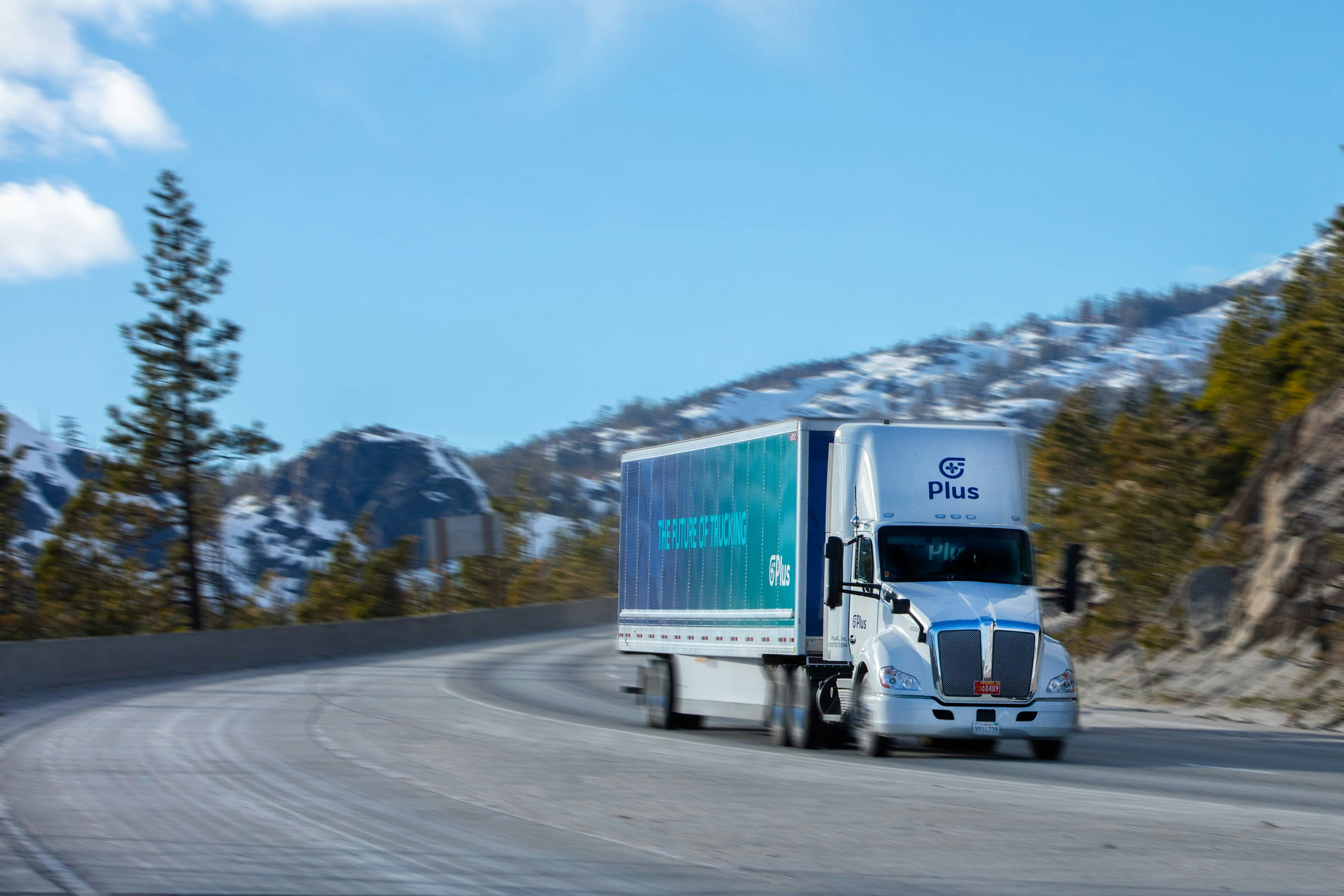 Plus AI truck on highway through snowy mountains