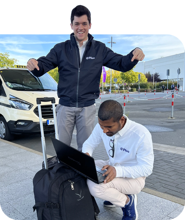 Plus employees with luggage at airport one working on laptop computer