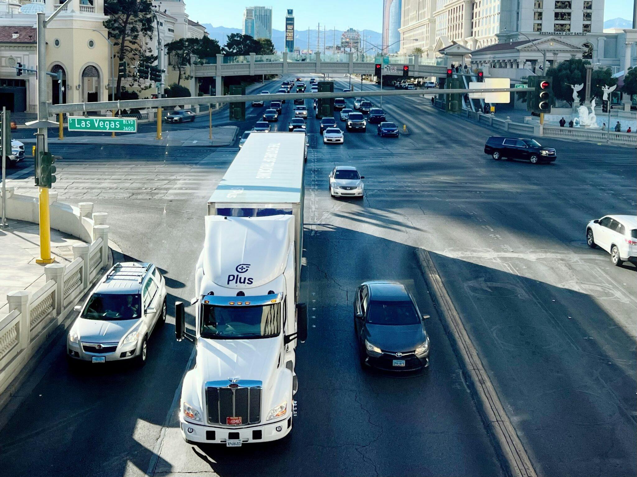 Autonomous Plus truck driving through city intersection
