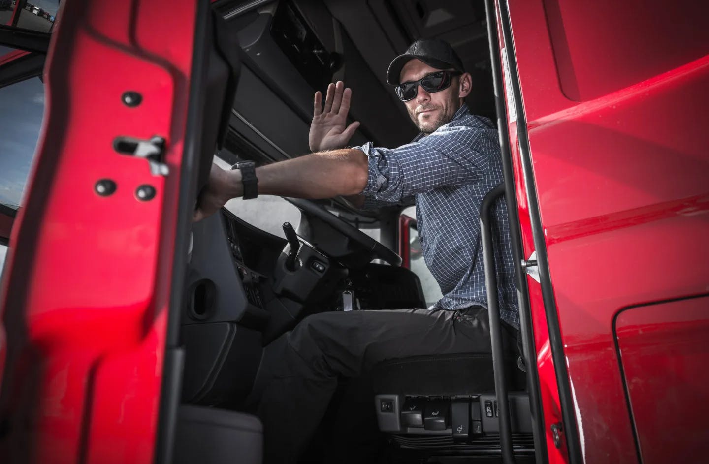Trucker waving from inside the cab of the truck